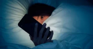 Person scrolling though social media in the middle of night.